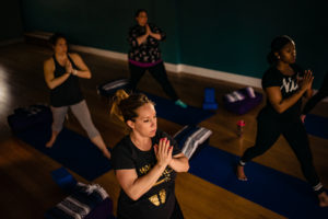 Pregnant women practice prayer pose during a prenatal yoga class at Full Circle Yoga in the heart of Kansas City.