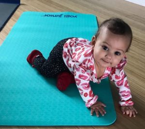 A baby crawls over a yoga mat during a Toddler Yoga: Parents and Little Movers class at Full Circle Yoga in Midtown Kansas City.