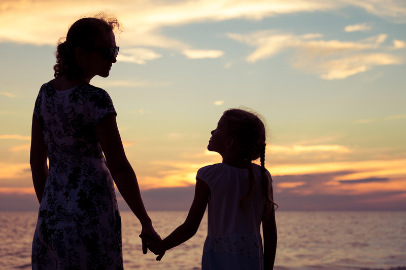 mother holding daughter's hand as she transitions throughout parenthood