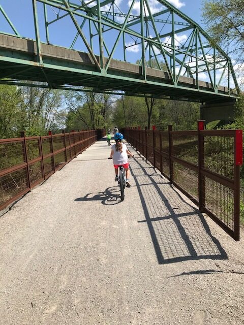 child riding a bike on a bridge while riding under a brdige
