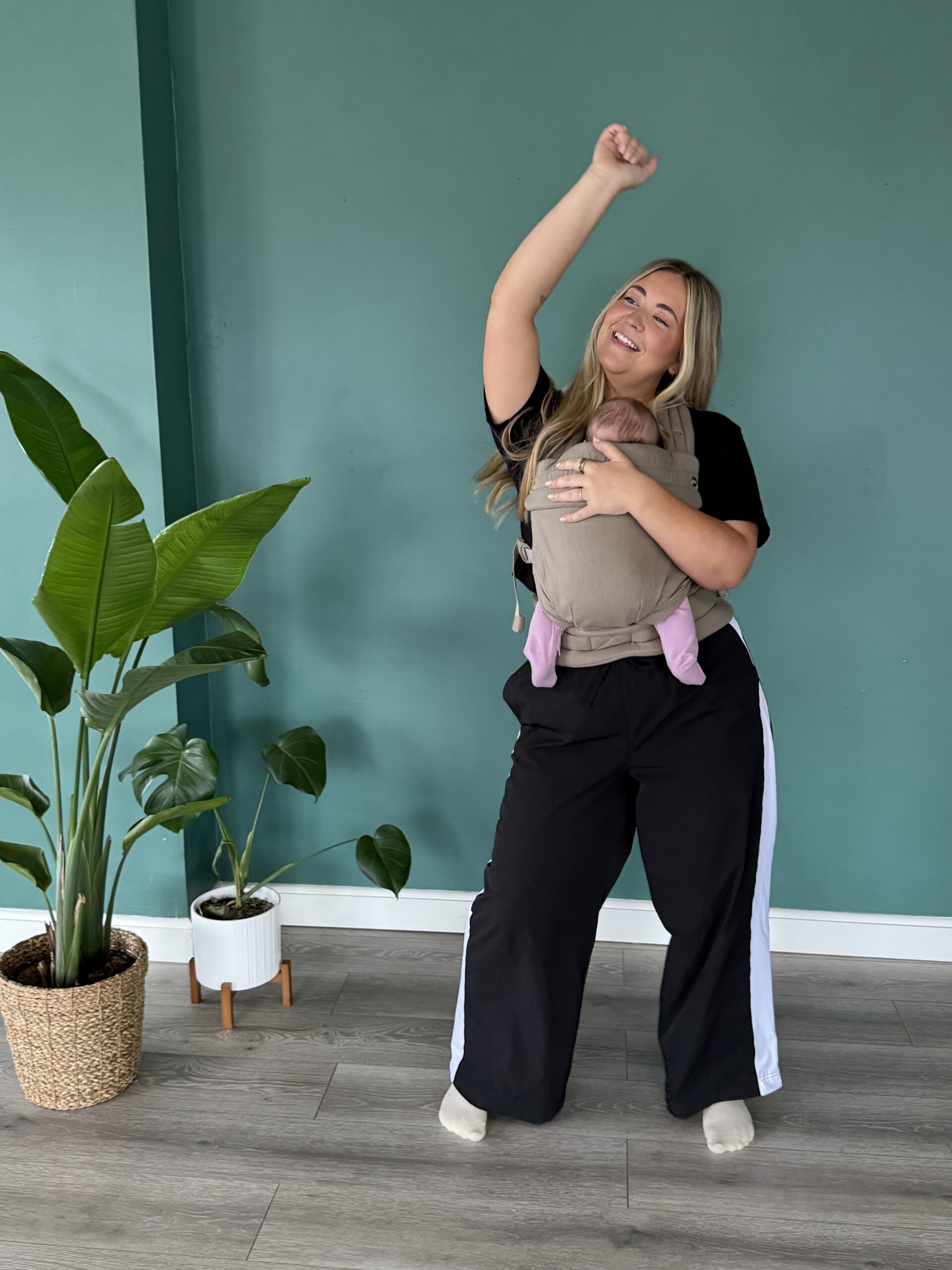 A mother dancing with her baby in a babycarrier at Full Circle Yoga KC